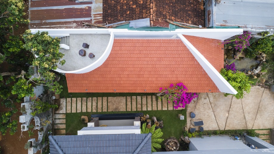 The house has a wide veranda and a raised platform.