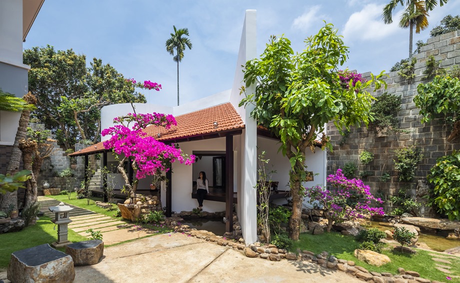 The house has a wide veranda and a raised platform.