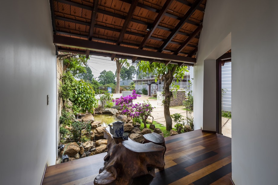 The house has a wide veranda and a raised platform.